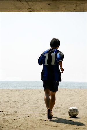 simsearch:622-01080599,k - Silhouette Of a Young Man With a Soccer Ball on the Beach Foto de stock - Sin royalties Premium, Código: 622-00947355