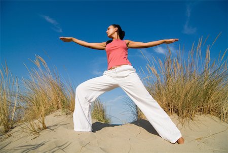 posture du guerrier - Jeune femme exerçant sur une dune de sable Photographie de stock - Premium Libres de Droits, Code: 622-01080549