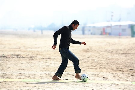 simsearch:622-01080599,k - Caucasian male practicing soccer on beach Foto de stock - Sin royalties Premium, Código: 622-01080600