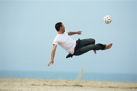 simsearch:622-01080599,k - Caucasian male practicing soccer on beach Foto de stock - Sin royalties Premium, Código: 622-01080603