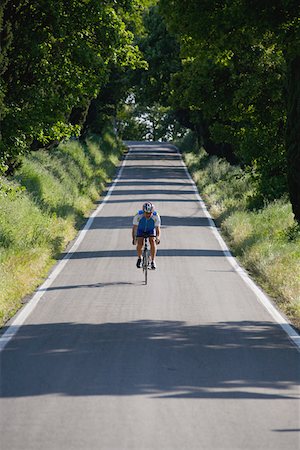 simsearch:858-03049522,k - Cyclist riding bicycle on deserted road,  front view Stock Photo - Premium Royalty-Free, Code: 622-02198546