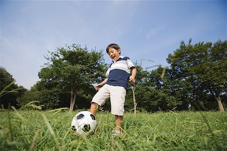 single pic of kids playing football - Boy playing with football in park Stock Photo - Premium Royalty-Free, Code: 622-02354137