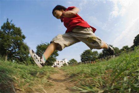 profile of boy jumping - Boy running in park Stock Photo - Premium Royalty-Free, Code: 622-02354145
