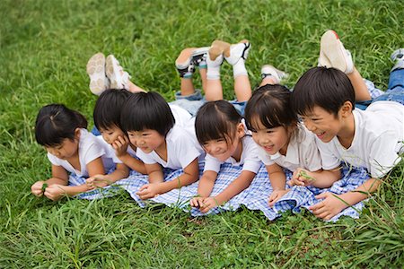 simsearch:622-02354181,k - Kinder, die auf der Vorderseite zusammen im Park liegend lächelnd Stockbilder - Premium RF Lizenzfrei, Bildnummer: 622-02354176