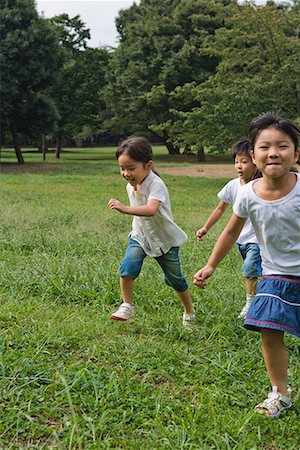 Trois enfants jouant ensemble dans un parc Photographie de stock - Premium Libres de Droits, Code: 622-02354239