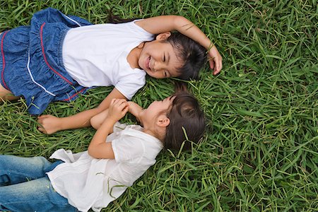 Two girls lying on grass in a park Stock Photo - Premium Royalty-Free, Code: 622-02354262