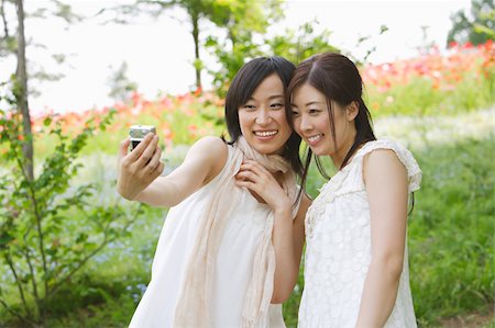 Young smiling woman taking their snap with digital camera Stock Photo - Premium Royalty-Free, Code: 622-02395529