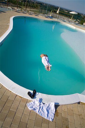 simsearch:622-02621605,k - Man jumping into swimming pool Stock Photo - Premium Royalty-Free, Code: 622-02621604