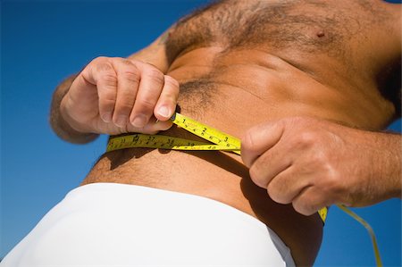 Man measuring his waist with a tape Foto de stock - Sin royalties Premium, Código: 622-02621619