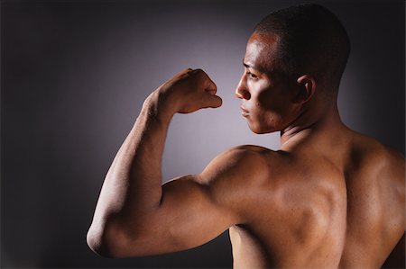 posing and back and one man - Young man showing biceps Stock Photo - Premium Royalty-Free, Code: 622-02621649