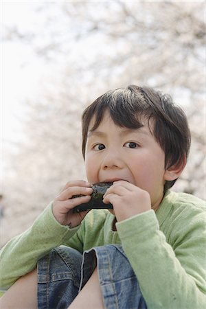 simsearch:859-03755279,k - Japanese boy de manger des sushis et regarder la caméra Photographie de stock - Premium Libres de Droits, Code: 622-02758470