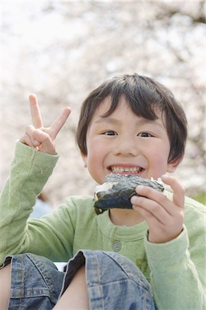 Japanese boy eating sushi and showing v sign Stock Photo - Premium Royalty-Free, Code: 622-02758471