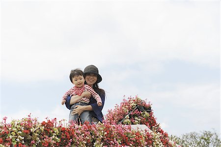 family in balcony - Mother holding baby on flowers decorated balcony against sky Stock Photo - Premium Royalty-Free, Code: 622-02758510