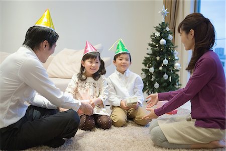 people decorate christmas tree - Family wearing party hats with birthday present Stock Photo - Premium Royalty-Free, Code: 622-02759097