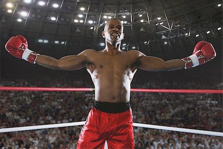 African boxer celebrating his victory by his arms outstretched Foto de stock - Sin royalties Premium, Código: 622-02913228