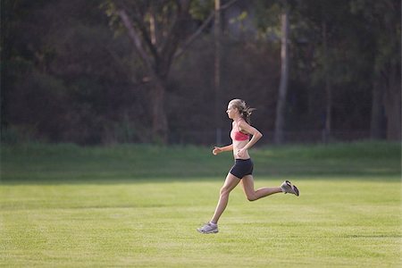 simsearch:640-02947561,k - Young Woman in tank top jogging on grass Stock Photo - Premium Royalty-Free, Code: 622-02913301