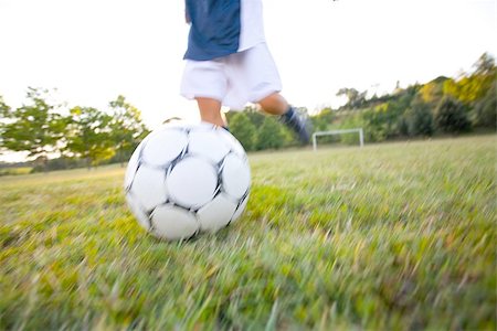 sports humor - Footballer kicking soccer ball Stock Photo - Premium Royalty-Free, Code: 622-02913354