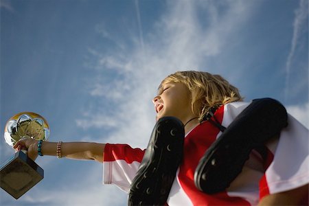 shout low angle - Soccer player holding shoes,trophy and shouting Stock Photo - Premium Royalty-Free, Code: 622-02913372