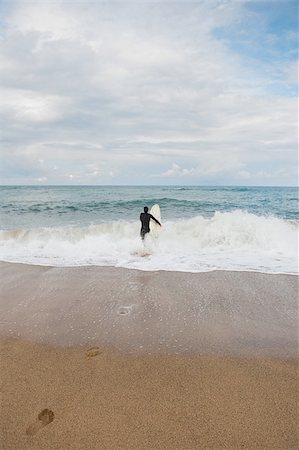 simsearch:622-02913397,k - Homme qui marche dans la mer avec planche de surf Photographie de stock - Premium Libres de Droits, Code: 622-02913403