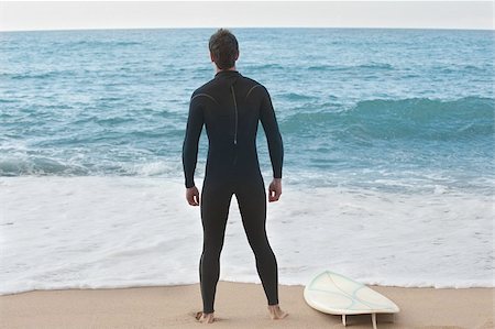 simsearch:622-02913397,k - Surfeur en wetsuit debout sur la plage Photographie de stock - Premium Libres de Droits, Code: 622-02913410
