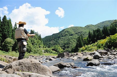 simsearch:622-02913459,k - Man with straw hat standing and holding fishing rod Fotografie stock - Premium Royalty-Free, Codice: 622-02913467