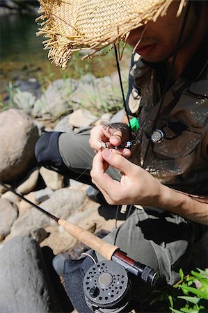 simsearch:622-02913459,k - Man with straw hat sitting and holding Dry Fly Fotografie stock - Premium Royalty-Free, Codice: 622-02913469