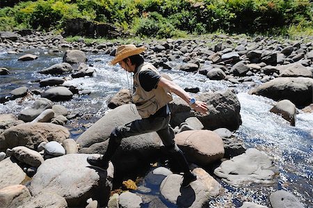 simsearch:622-02913468,k - Man with straw hat walking on stones Foto de stock - Sin royalties Premium, Código: 622-02913462