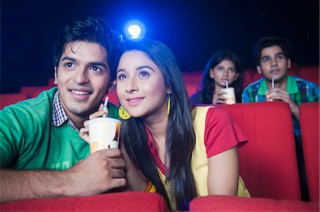 sala de cine - Couple enjoying soft drinks while watching movie in a cinema hall Foto de stock - Sin royalties Premium, Código: 630-06724511