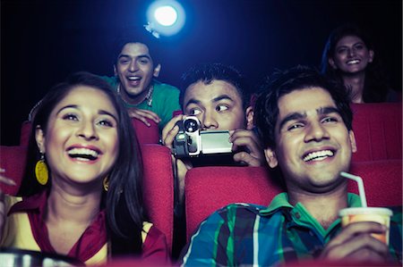 Man using video recorder in a cinema hall Foto de stock - Sin royalties Premium, Código: 630-06724520