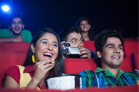 Man using video recorder in a cinema hall Foto de stock - Sin royalties Premium, Código: 630-06724521