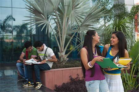 student carrying books - University students discussing on a book in university campus Stock Photo - Premium Royalty-Free, Code: 630-06724586