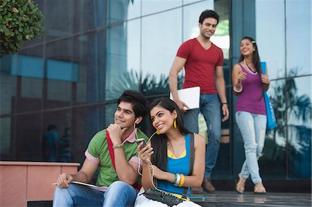 University students listening to music on a mobile phone Stock Photo - Premium Royalty-Free, Code: 630-06724581