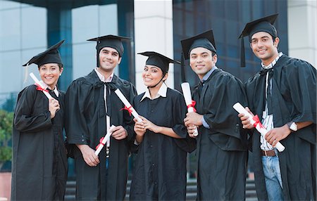 Portrait of graduate students holding diplomas and smiling in university campus Stock Photo - Premium Royalty-Free, Code: 630-06724598