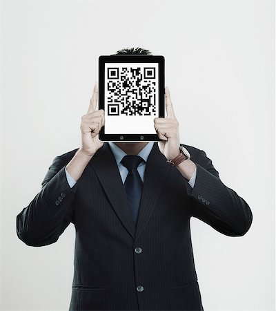 retail white background - Businessman holding a digital tablet in front of his face with 2D barcode on it Stock Photo - Premium Royalty-Free, Code: 630-06724610