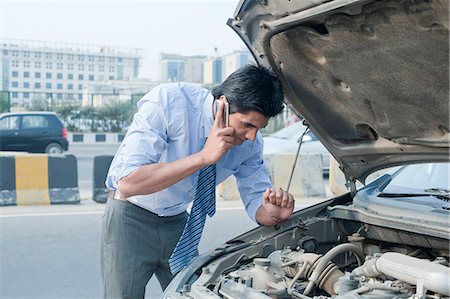 picture of person talking on string telephone - Businessman using a mobile phone near a broken down car, Gurgaon, Haryana, India Stock Photo - Premium Royalty-Free, Code: 630-06724627