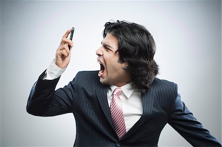 Frustrated businessman shouting over a mobile phone Stock Photo - Premium Royalty-Free, Code: 630-06724736