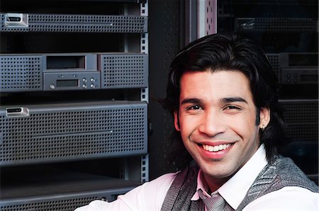 Networking engineer smiling in a server room Stock Photo - Premium Royalty-Free, Code: 630-06724772