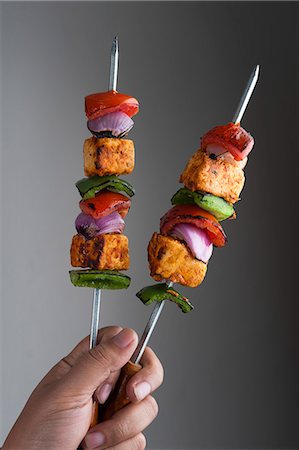 Close-up of a person's hand holding grilled vegetable kebab Photographie de stock - Premium Libres de Droits, Code: 630-06724857