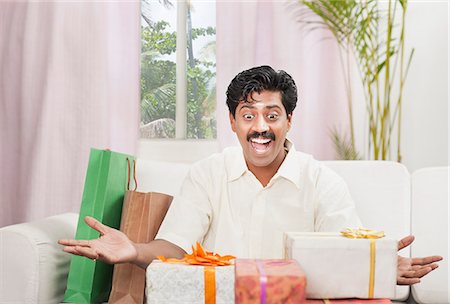 South Indian man smiling near gift boxes Foto de stock - Sin royalties Premium, Código: 630-06724937