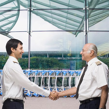 Two pilots shaking hands and smiling Stock Photo - Premium Royalty-Free, Code: 630-06721843