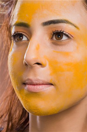 Close-up of a woman with turmeric on her face Stock Photo - Premium Royalty-Free, Code: 630-06721902