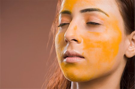 Close-up of a woman with turmeric on her face Photographie de stock - Premium Libres de Droits, Code: 630-06721903