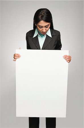 Businesswoman holding a placard Stock Photo - Premium Royalty-Free, Code: 630-06721996