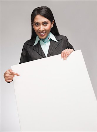 Businesswoman showing a placard and smiling Stock Photo - Premium Royalty-Free, Code: 630-06721998