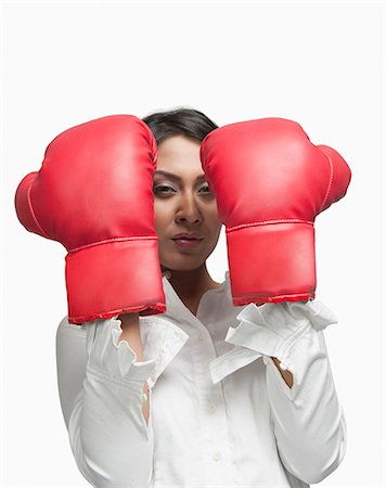 portrait of confident businesswoman studio - Portrait of a businesswoman wearing boxing gloves Stock Photo - Premium Royalty-Free, Code: 630-06722019