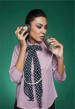 person talking old fashioned phone - Businesswoman using a tin can phone Stock Photo - Premium Royalty-Free, Code: 630-06722058