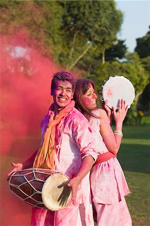 Couple celebrating Holi with musical instruments in a garden Stock Photo - Premium Royalty-Free, Code: 630-06722096