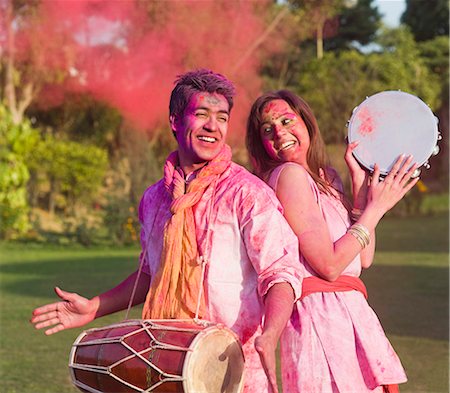 drums play - Couple celebrating Holi with musical instruments in a garden Stock Photo - Premium Royalty-Free, Code: 630-06722097