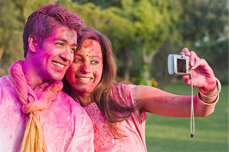 Couple taking a picture of themselves on Holi Stock Photo - Premium Royalty-Free, Code: 630-06722110
