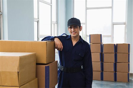 delivery (goods and services) - Delivery man with cardboard boxes in a warehouse Stock Photo - Premium Royalty-Free, Code: 630-06722236